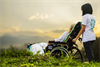 Altenpfleger schiebt eine Patientin die im Rollstuhl sitzt